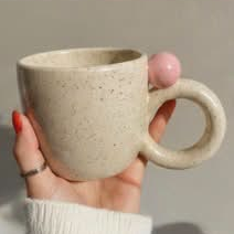 Speckled pebble mug held in hand